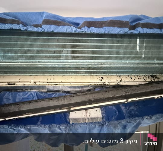 מזגן עם כיסוי כחול בתהליך ניקוי
